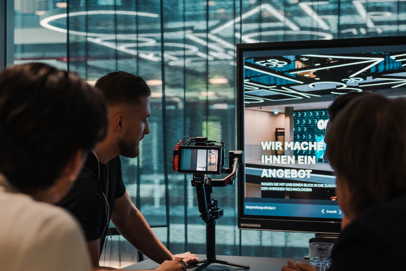 Gimbal camera operator and client review on a NextFlow Studios video production set in Munich